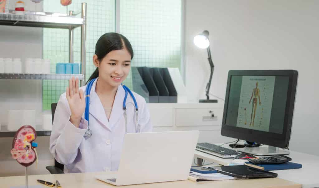 A young Asian female doctor works alone at her desk, reviewing kidney-related medical data. files and calm clinical atmosphere,she concentrates on providing accurate diagnosis and treatment planning
