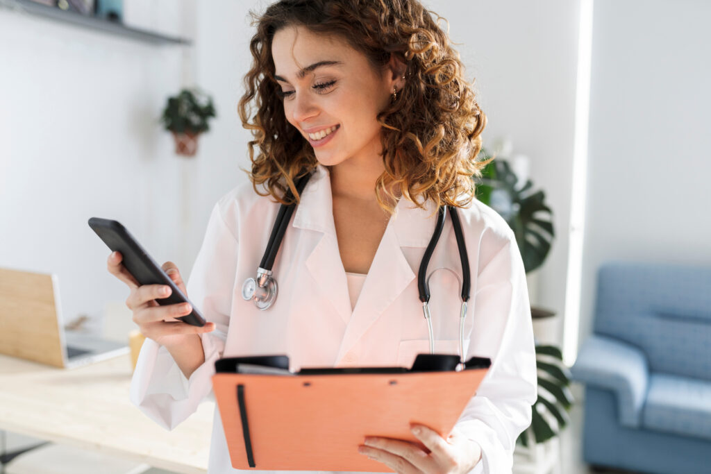 female doctor in consultation with folder and mobile phone